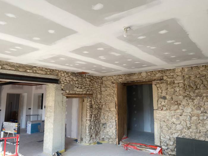 Plafond en plaques de plâtre avec bandes, murs en pierre apparente conservés – rénovation dans la Drôme – Cabesos & Fils